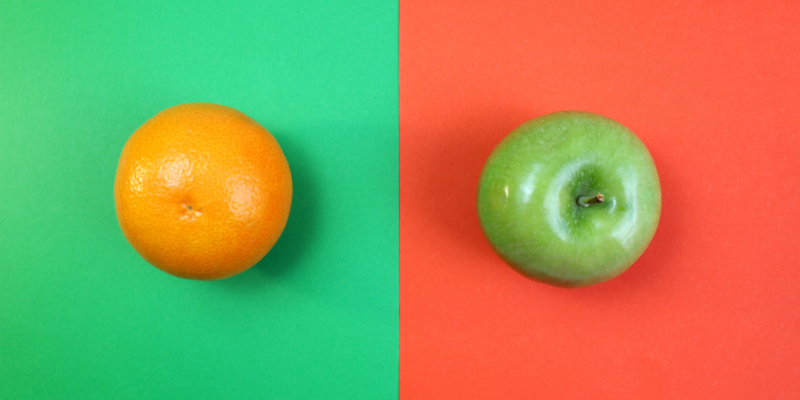 An orange (the fruit) sits on a green background, while a green apple sits against a red-orange background